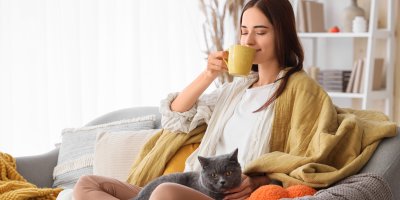 Žena pije čaj a má u sebe kočku
