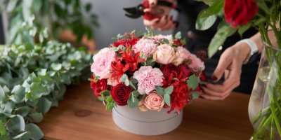 Dárková krabička vyplněná růžemi v červených a růžových odstínech v květinářství