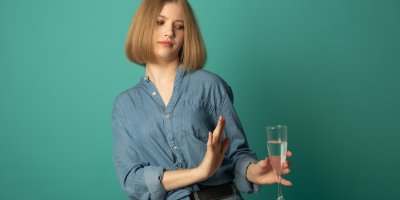 Mladá žena odmítá skleničku alkoholu