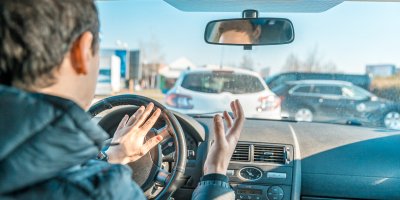 Řidič za volantem troubí a rozčiluje se