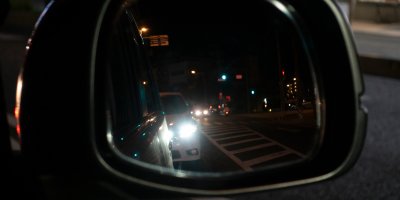 Auto ve tmě ve zpětném zrcátku