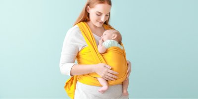 Matka nosí miminko v šátku