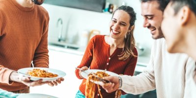 Skupina přátel, kteří jí těstoviny