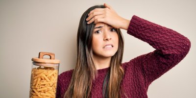 Žena, která drží v ruce dózu s těstovinami