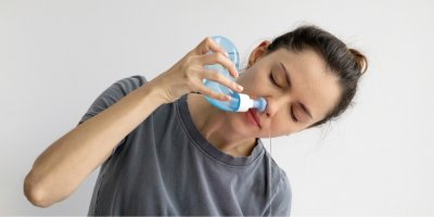 Mladá žena si vyplachuje nos 