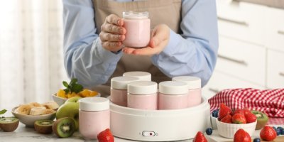 Člověk používá jogurtovač na přípravu jogurtů