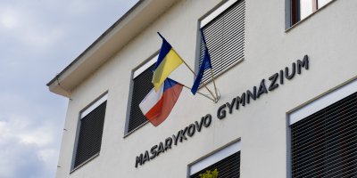 Budova gymnázia s vyvěšenými vlajkami