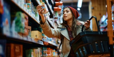 Člověk čte etiketu na konzervě v obchodě