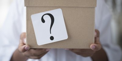 Člověk drží krabici s otazníkem