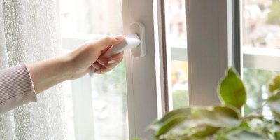 Žena otevírá okno