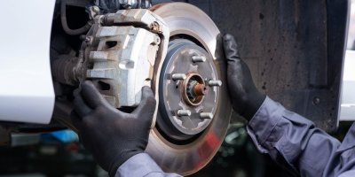 Automechanik drží oběma rukama brzdový kotouč