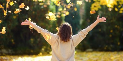 Mladá žena se cítí skvěle během procházky, kolem podzimní listí