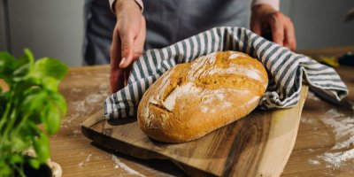 Domácí chleba a lněná utěrka na dřevěném prkénku