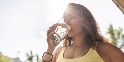 Žena pije vodu venku