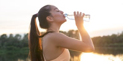 Žena pije venku vodu z plastové lahve