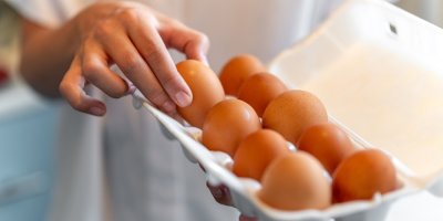 Ruka vytahuje vajíčko z krabičky.