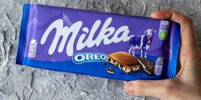 Člověk drží čokoládu Milku Oreo