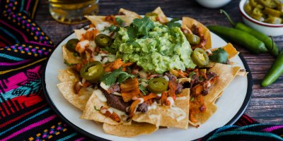 Nachos s masem a guacamole na talíři