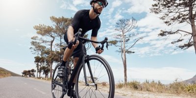 Muž jede na kole po silnici