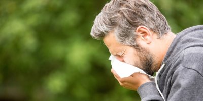 Muž smrká do kapesníku