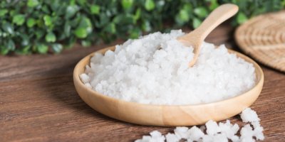 V ruce v zahradnické rukavici je hrst epsomské soli