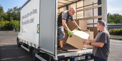 Pracovník předává muži balík ze skříňového automobilu společnosti IKEA 