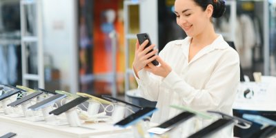 Žena v obchodě vybírá telefon