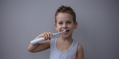 Chlapec si čistí zuby elektrickým kartáček