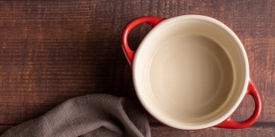 Keramický hrnec s červenými uchy a utěrka