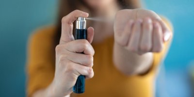 Žena si stříká parfém na ruku