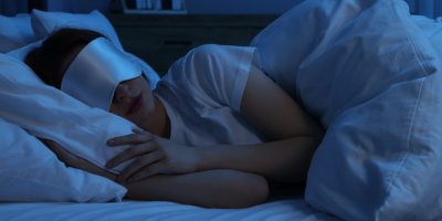 Spící žena s noční maskou na oči