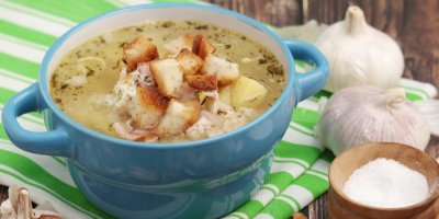 Česneková polévka v rendlíku, kolem česnek a sůl