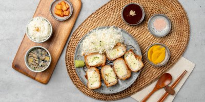 Rozkrojený řízek s mozzarellou, okolo různé přílohy