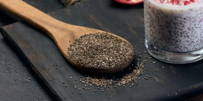 Chia semínka na dřevěné lžíci, jogurt s chia semínky ve sklenici