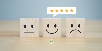 Koncept zákaznické spokojenosti, tři kostičky se symbolem neutrálního, spokojeného a nespokojeného výrazu 