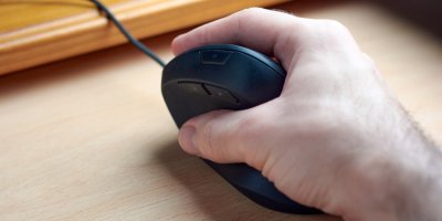 Mužská ruka drží vertikální myš