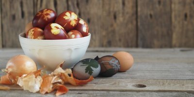 Obarvená vejce v misce, vedle jsou vejce v silonce a cibule