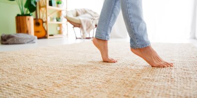 Bosé nohy chodí po koberci