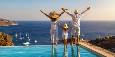 Tříčlenná rodina u bazénu s výhledem na moře