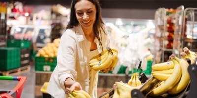 Žena vybírá banány v supermarketu 