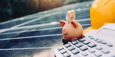 Kasička s penězi a kalkulačka