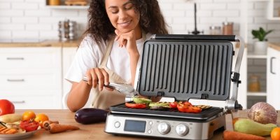 Žena připravuje zeleninu na elektrickém grilu