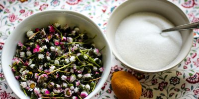 Natrhané sedmikrásky v misce, citrón, cukr krystal v misce