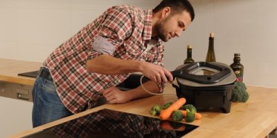 Muž se dívá pod pokličku pečenky