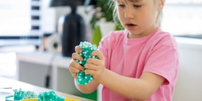 Holčička si hraje se slizovou hračkou