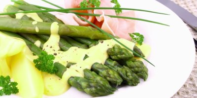 Chřest v holandské omáčce na bílém talíři