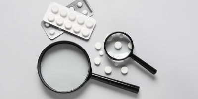 Dvě přibližovací lupy a léčiva ve formě tablet