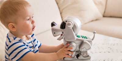 Chlapeček si hraje s robotickým pejskem
