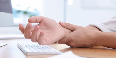 Jedna ruka drží druhou na karpálech