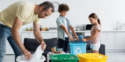 Muž s dětmi třídí odpad.